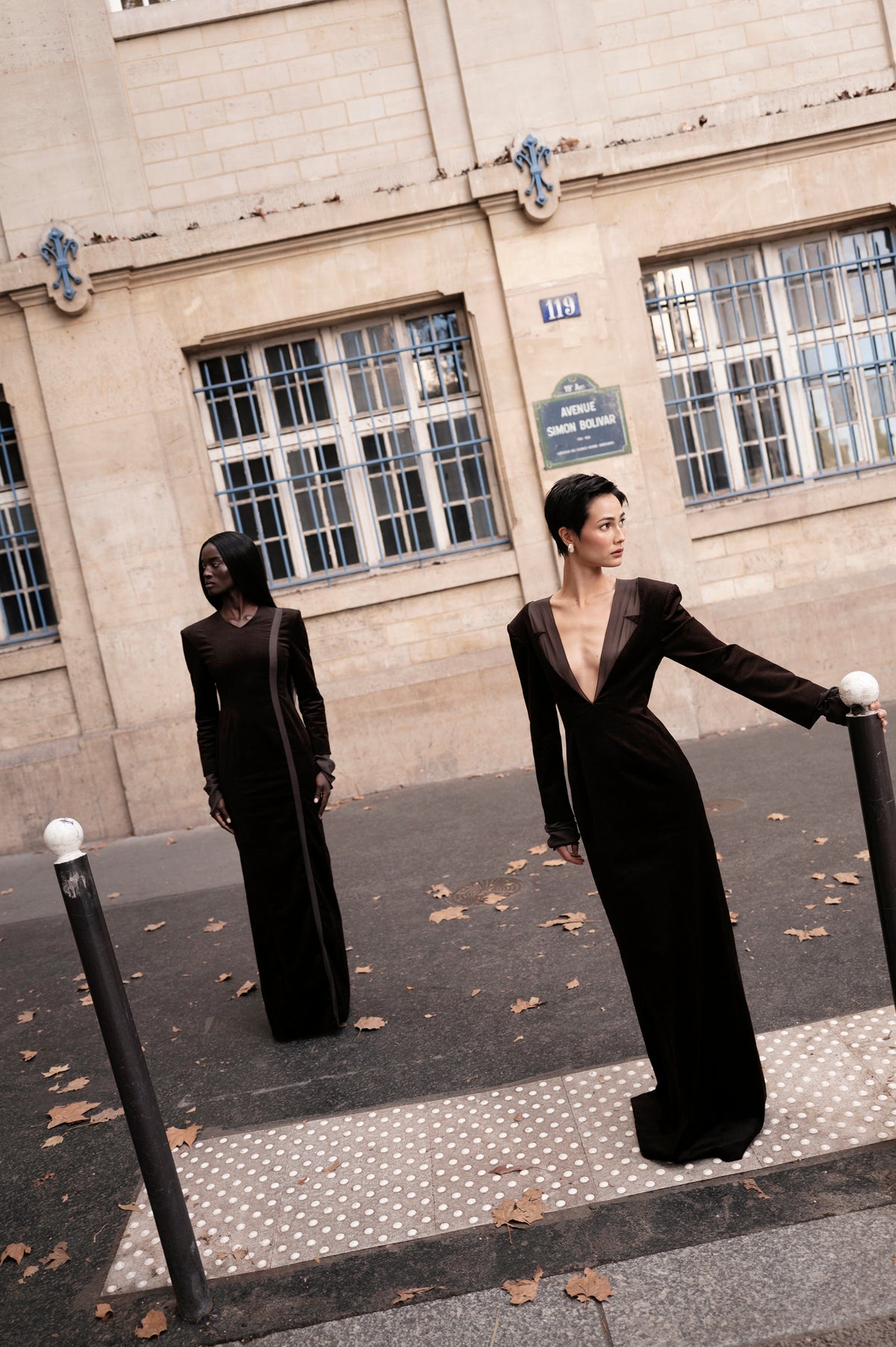 Black floor-length dress with silk detail, editorial group scene outdoors