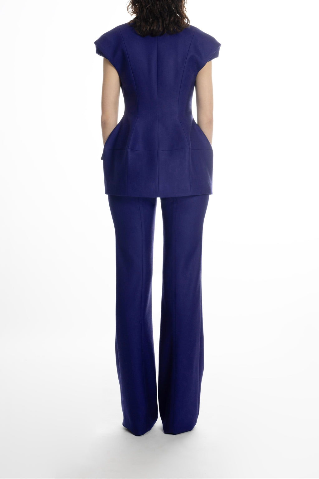 Women’s deep blue hip-length blazer, back view showing sculpted waist and clean seams