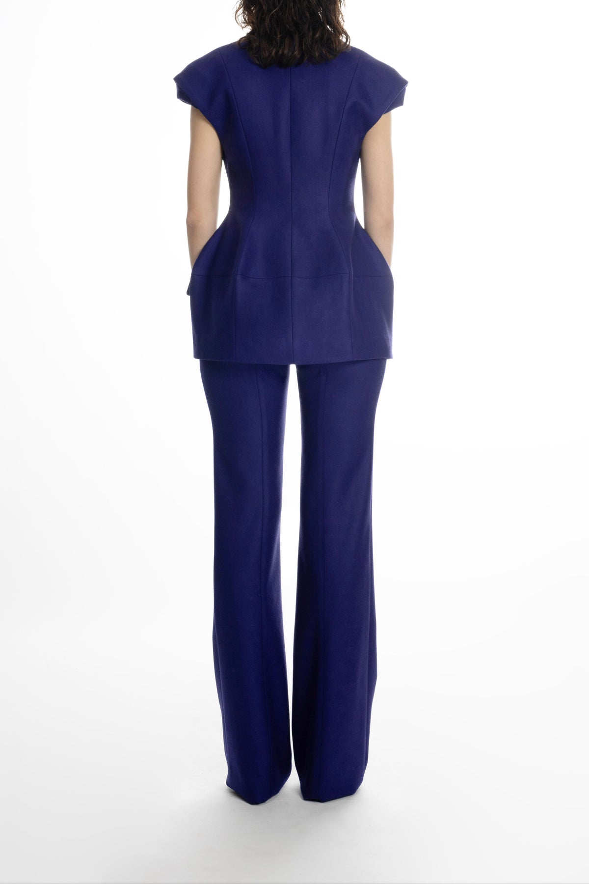 Women’s deep blue hip-length blazer, back view showing sculpted waist and clean seams