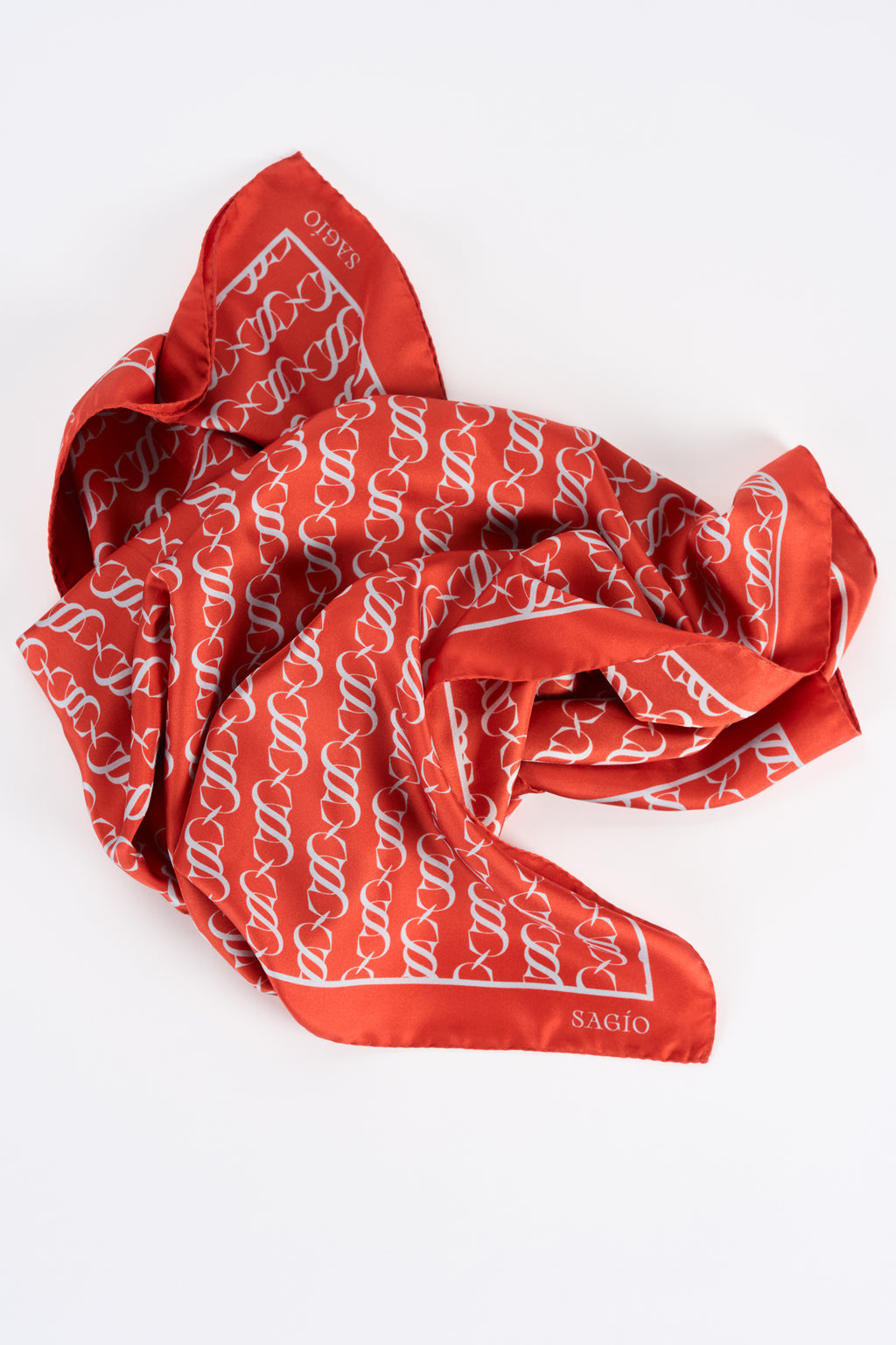 Vermilion red designer silk scarf in twill with white monogram motif in draped view