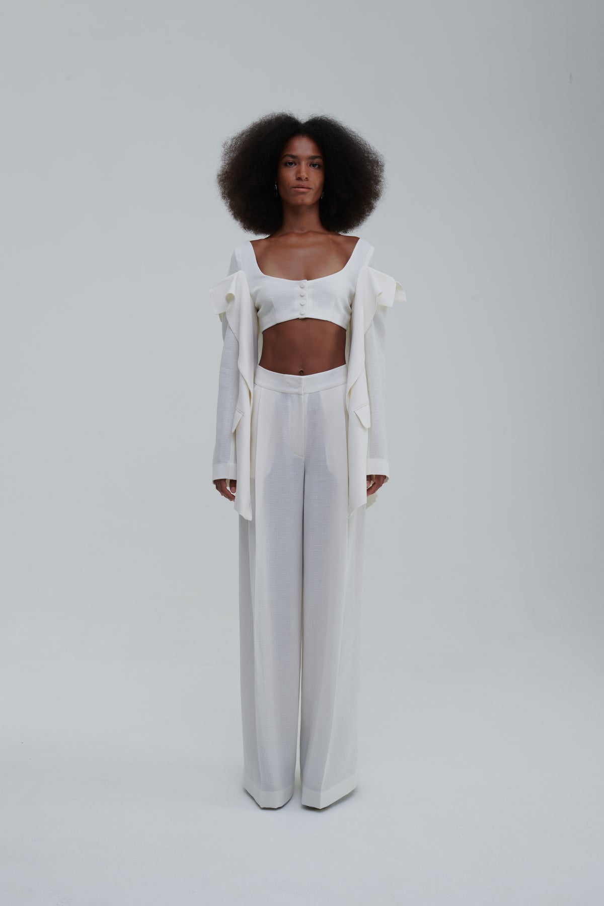 White falling-jacket crop top, front view, draped panels and covered buttons