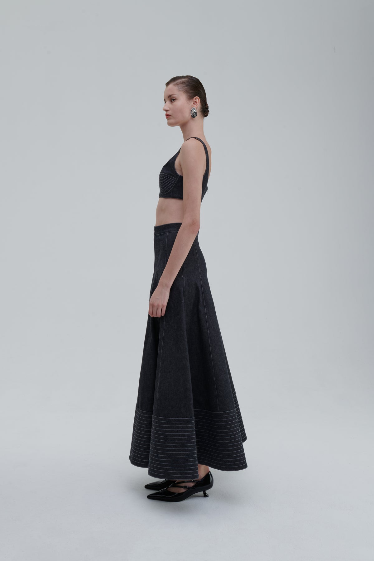 Side view of model wearing SAGIO Quilted Denim Top and matching skirt