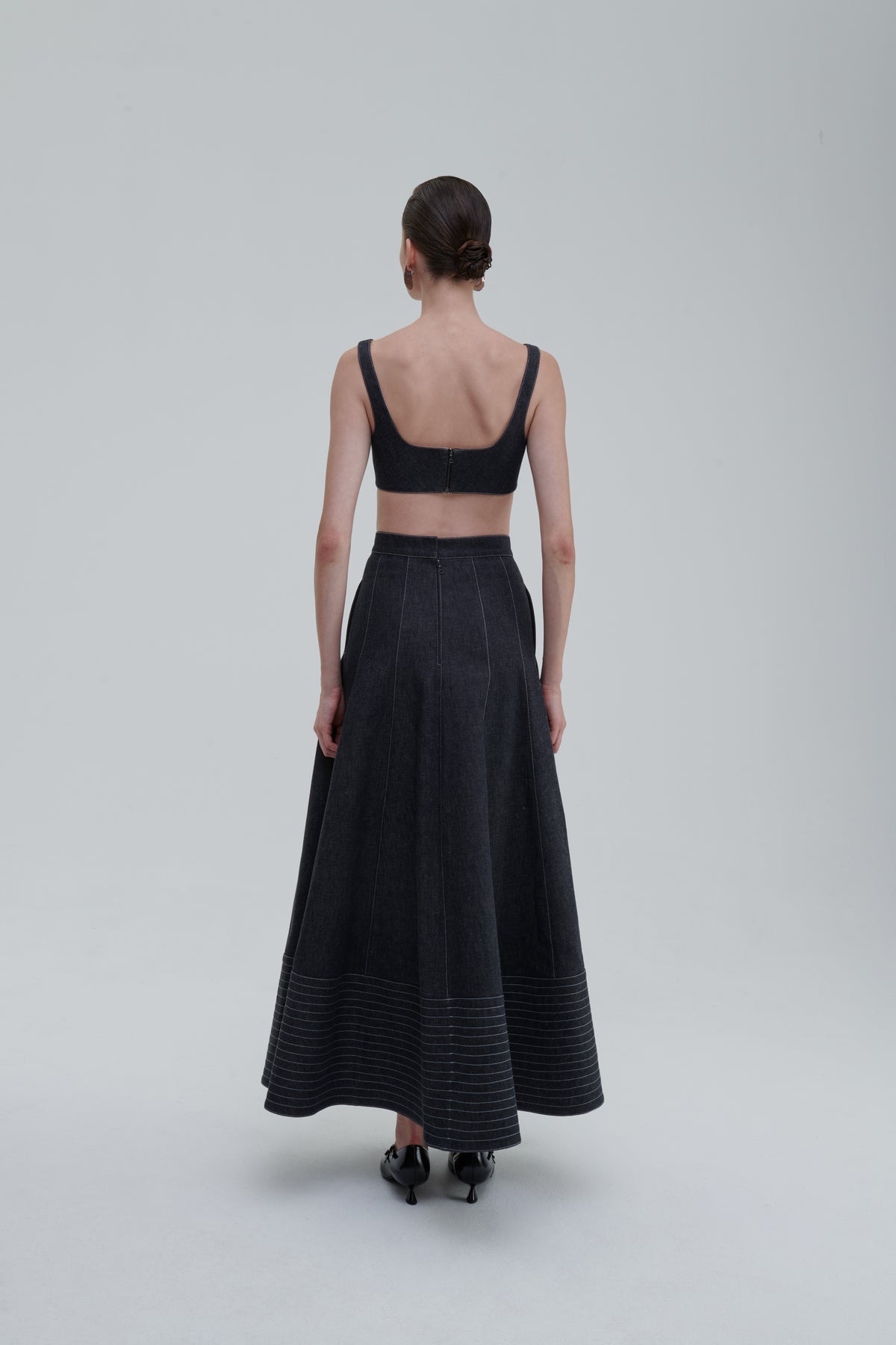 Back view of model wearing SAGIO Quilted Denim Top and matching skirt