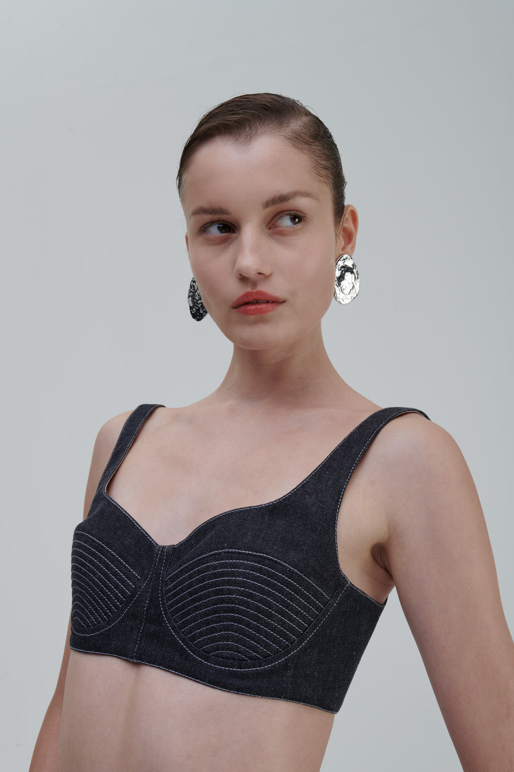 Close-up portrait of model wearing SAGIO Quilted Denim Top in dark denim