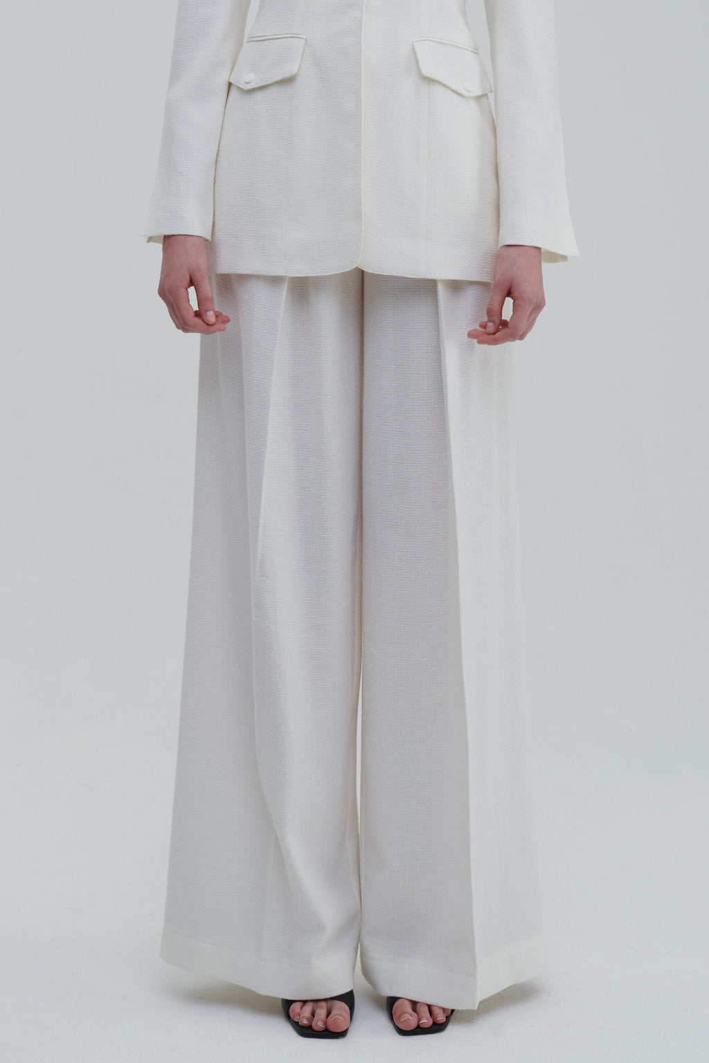 White classic palazzo trousers detail, front lower view with wide-leg drape