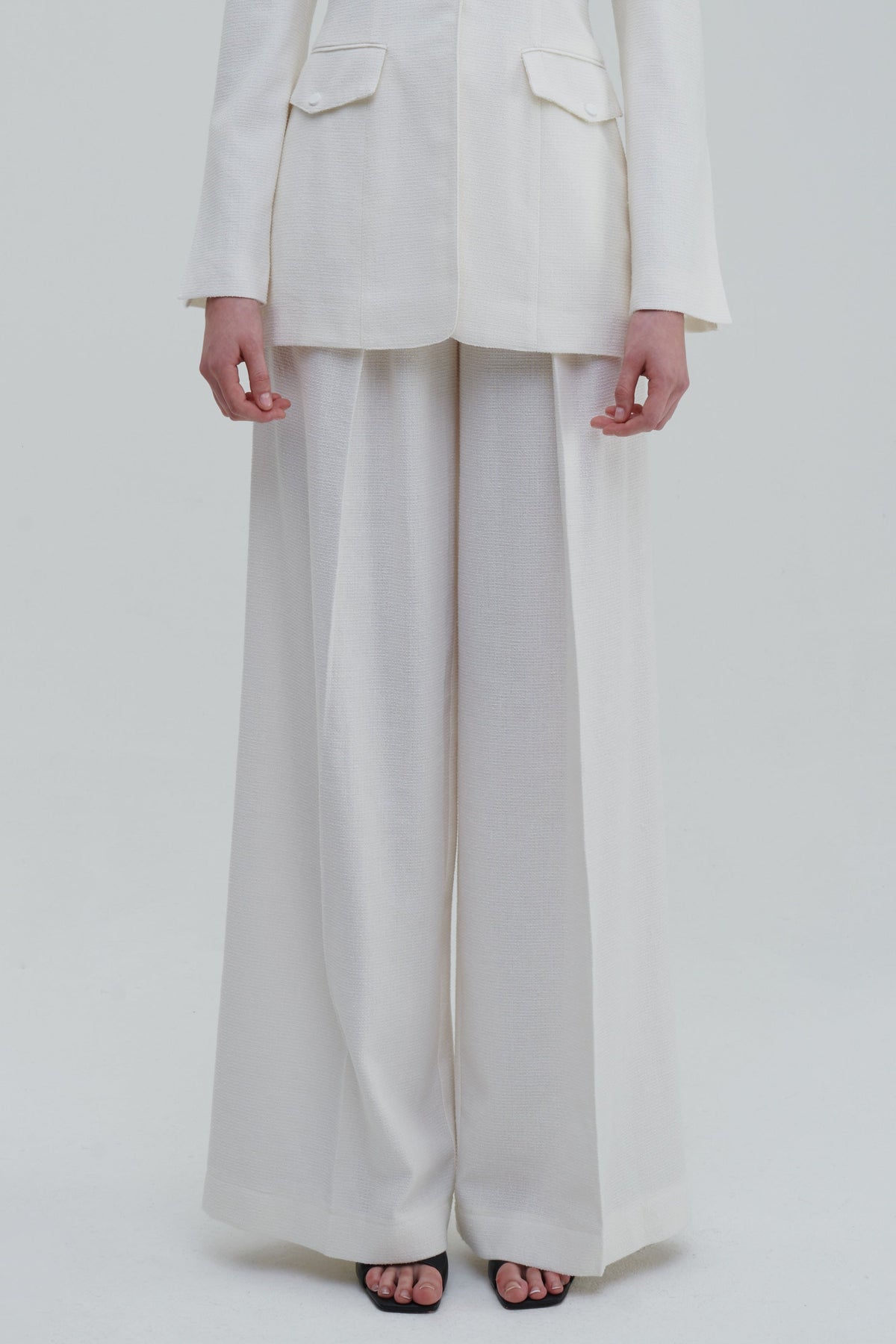 White classic palazzo trousers detail, front lower view with wide-leg drape