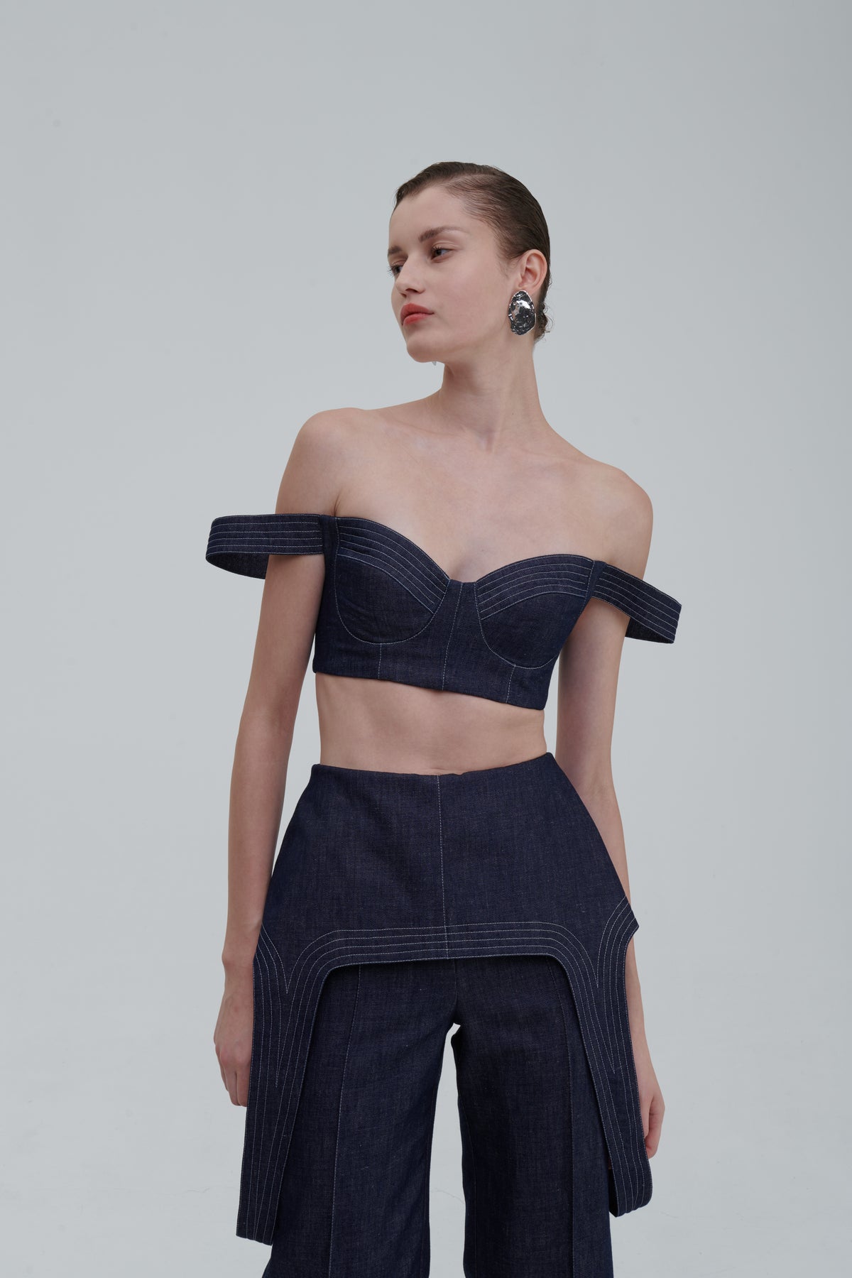 Dark indigo denim falling top with off-shoulder straps, three-quarter front view