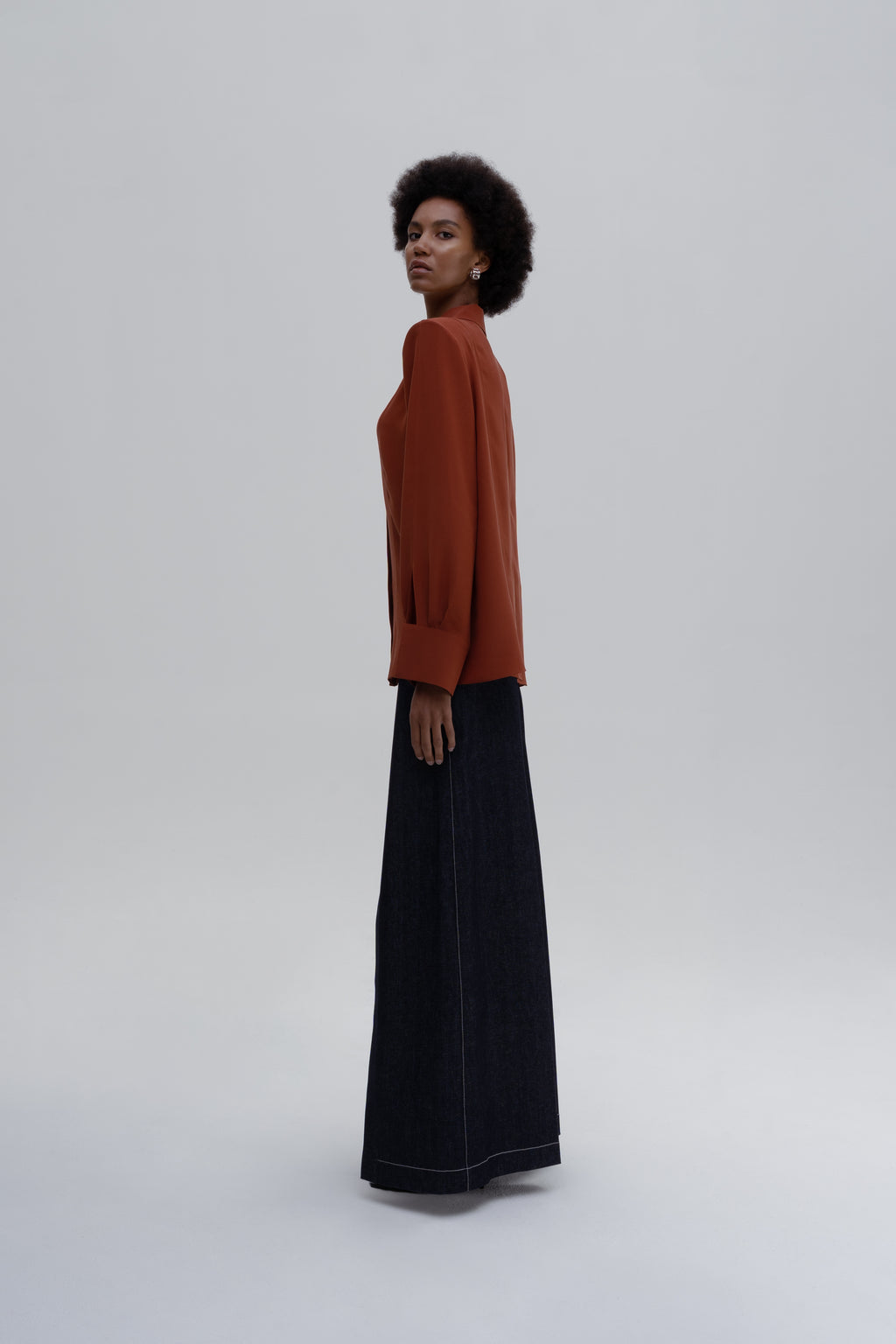 Silk Shirt by Sagio, featuring a relaxed-fit, long-sleeve red silk blouse with a classic collar and concealed button placket, side view. 
