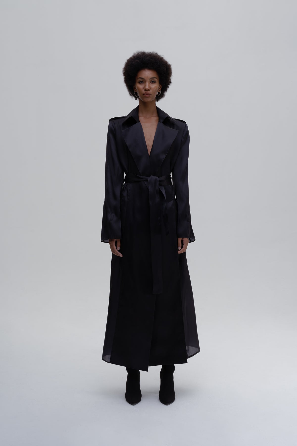 Model wearing the SILK SLITS TRENCH COAT by Sagio from the Spring/Summer 2025 collection — a lightweight, fluid trench coat crafted from soft silk, featuring high side slits, a relaxed silhouette, and a modern minimalist design. Explore the full look at thesagio.com